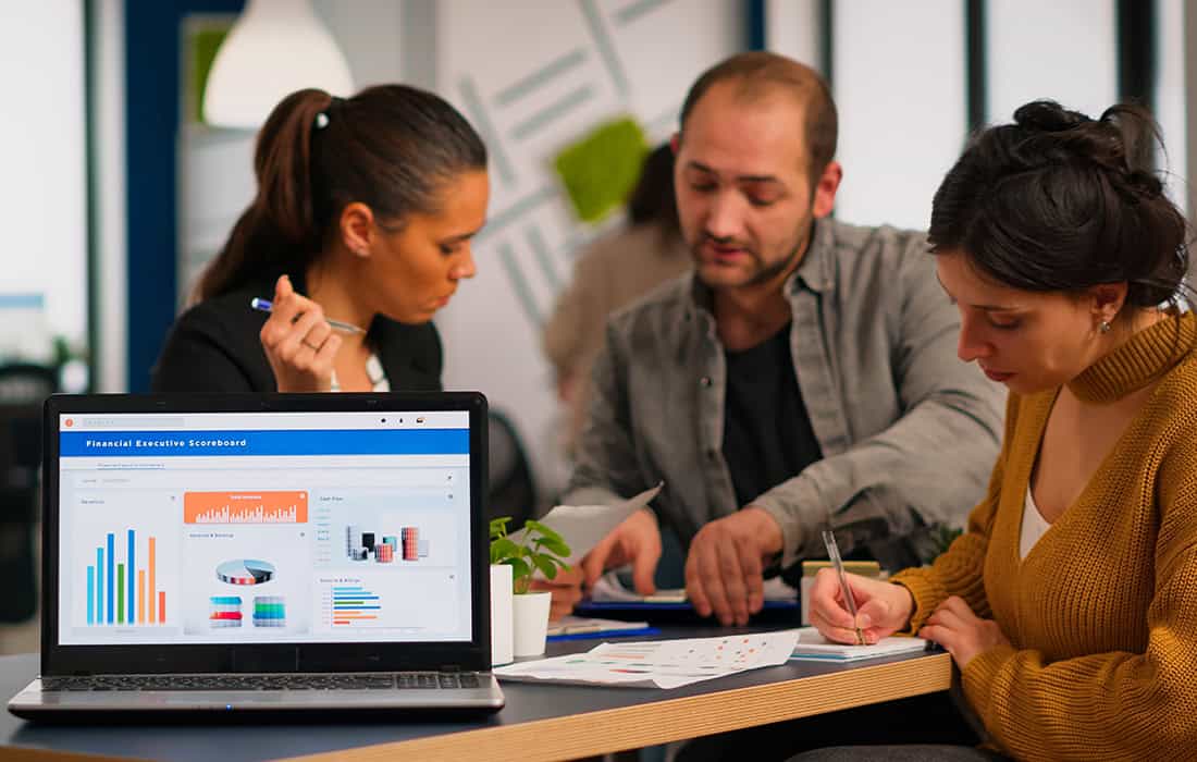 Marketing team analyzing data and strategy with laptop in office